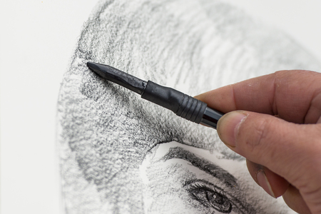 Designer with Charcoal drawing a faceの写真素材