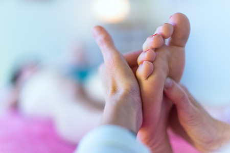 Close up of therapist's hands massaging female foot Close up of therapist's hands massaging female foot