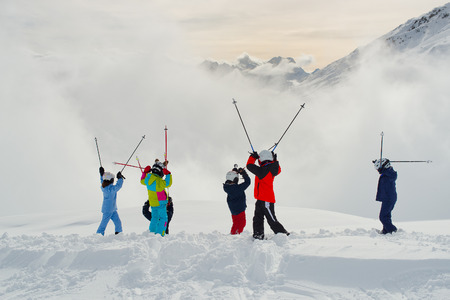 Small children skiers with arms raisedの写真素材