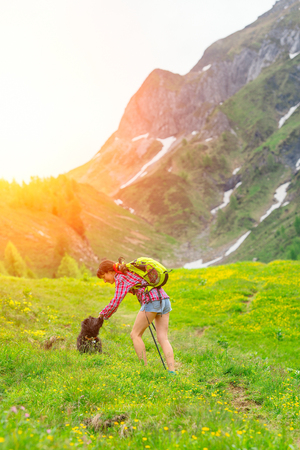 Girl playing with her dog during walk in the mountainsの写真素材