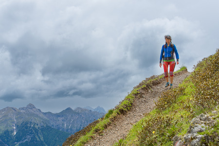 Girl mountain trail walks alone in the summerの写真素材