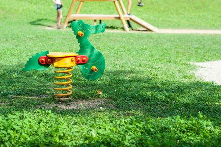 green rocking chair  in a green area for children iin italyの写真素材