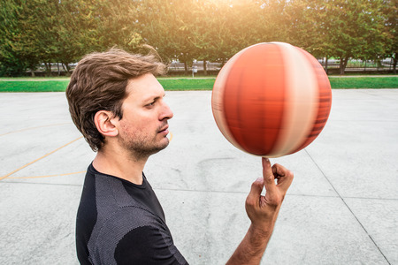Performance of a white basketball player on the outdoor field in the city roadの写真素材