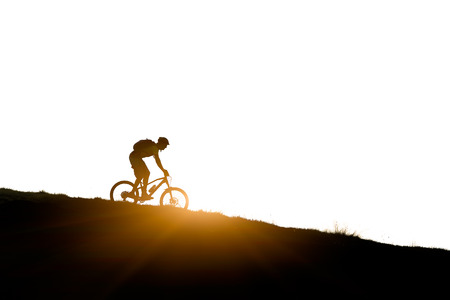 Cyclist in the mountains  downhill mountain bike in silhouetteの写真素材