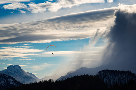 Paragliding in the mountains between wind and clouds in winterの写真素材