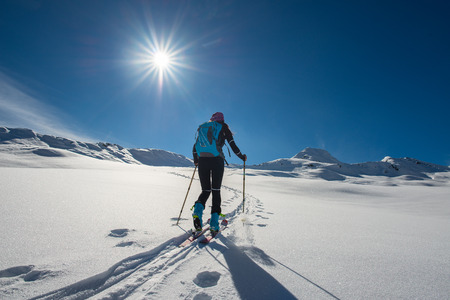 uphill girl with seal skins and ski mountaineering on the alpsの写真素材