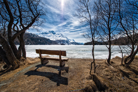 Wooden bench to admire the scenery on an alpine lake ice near Sankt Moritz in Switzerlandの写真素材
