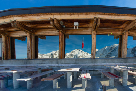 Tables of the restaurant at high altitude with the view of the landscape of glaciers reflected in glass windows in Switzerlandの写真素材