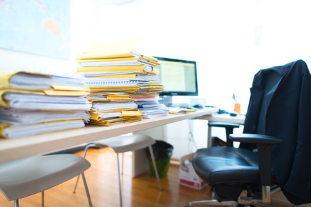 Bundles of documents and folders on empty commercial office desk