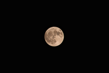 Full yellow moon on dark sky background.