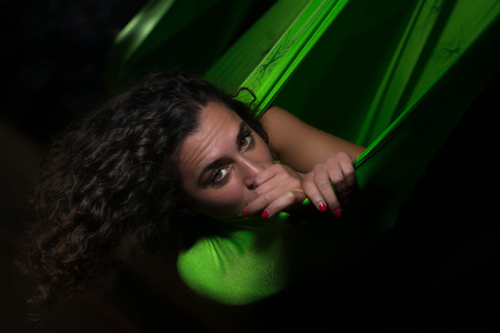 Closeup portrait of girl posing in a green silk hammock - aerial anti gravity yoga concept.の写真素材