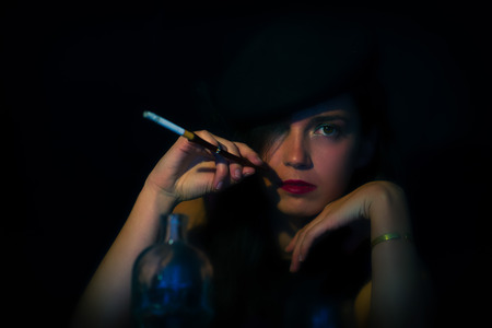 Retro woman with mouthpiece cigarette and alcohol. retro style.の写真素材