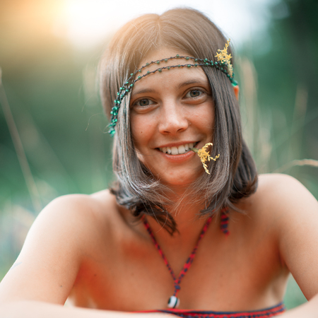 Portrait of a Woodstock Hippie style girl. With flower in the mouth. deliberately vintage photographの写真素材