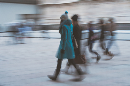 Blurred effect with group of girlfriends girls walking in the city in winter.の写真素材