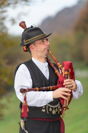 Typical player in traditional northern Italy bagpipe costume, an alpine valley of Bergamo.の写真素材