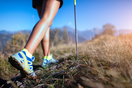 Nordic Walking on dirt road. A young woman in te mountain.の写真素材