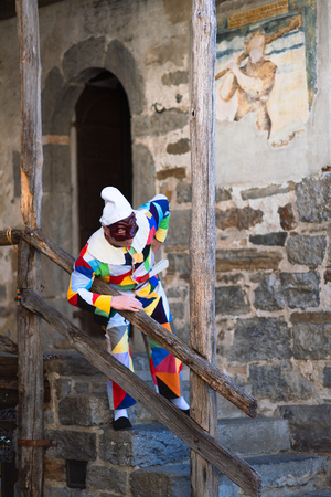 ONETA, BERGAMO, ITALY - MARCH - 30 - 2019: The mask of Arlecchino. on the stairs of Oneta's house. Valle Brembana. Bergamo. Italyのeditorial素材