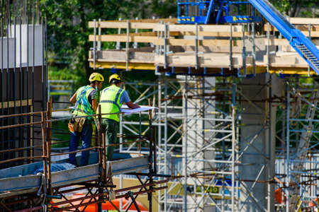 San Pellegrino terme, Italy, 09.08.2020: Men on construction site consult full of work