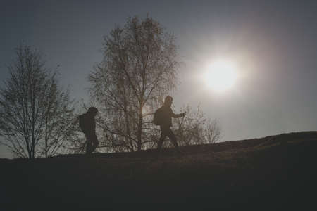 Woman with a child walk on the hill in the autumn sunの写真素材