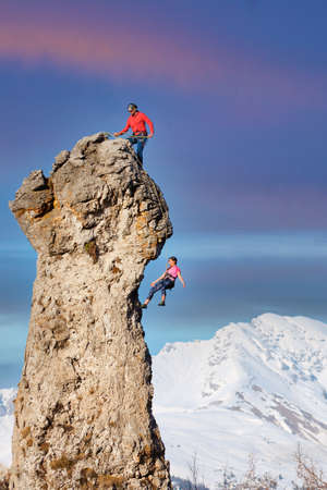 Rocky peak with a couple of climbers in ropesの写真素材