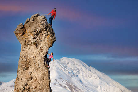 Rocky peak with a couple of climbers in ropesの写真素材