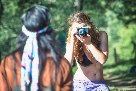 Pair of hippie girls by a lake are relaxingの写真素材