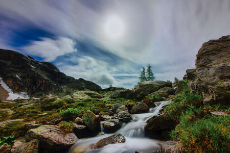 Mountain landscape with small waterway in summer