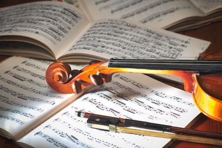 Violin with bow resting on musical scoreの写真素材