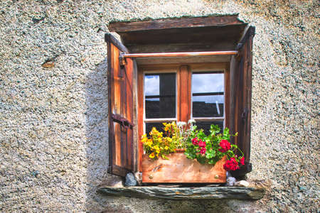 Typical window of the Swiss Alps. With flowersの写真素材