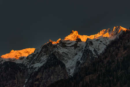 Mountains of snow in the Swiss Alps colored by the setting sun