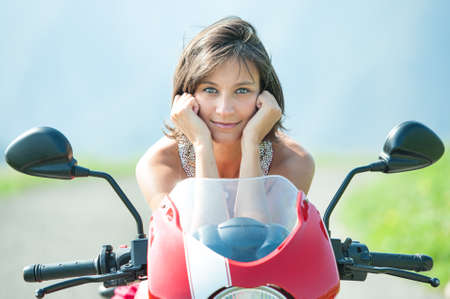 Close-up of a beautiful dark-haired girl on top of the motorcycle