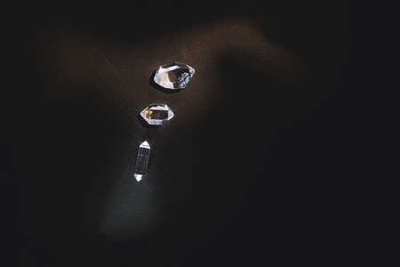 Three specimens of bi-terminated hyaline quartz illuminated by lights of a different color on black backgroundの写真素材