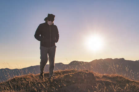 A man walks up the hill wearing a virus protection mask