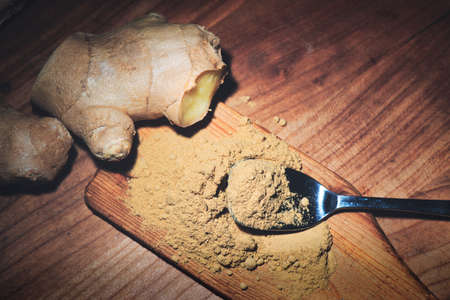 Ginger root and ginger powder on woodの写真素材