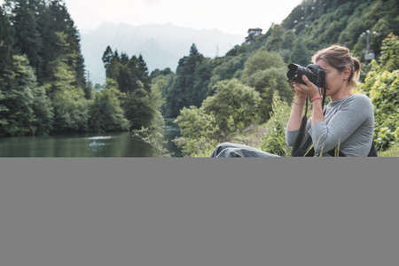 Young woman tries her hand at landscape nature photographyの写真素材