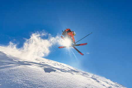A boy performs an off-piste ski jumpの写真素材