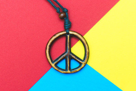The wooden peace symbol on yellow blue and red colors