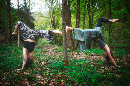Acrobatic yoga practiced by young female couple in nature
