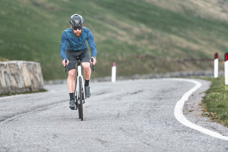 Young male athlete uphill on his bicycle