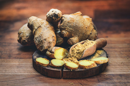 Ginger root with powder on cutting boardの写真素材