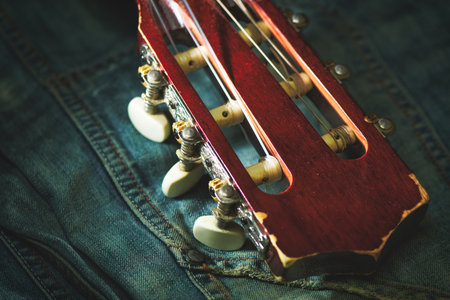 Classical guitar headstock resting on jeans