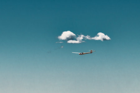 A glider flies in the sky on the Italian alpsの写真素材