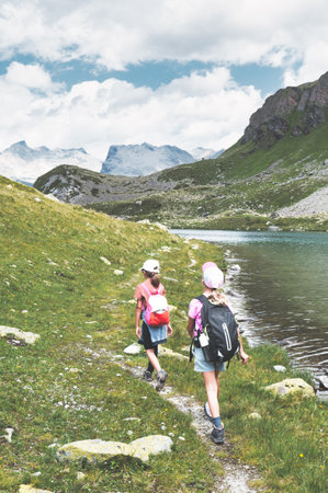 Two girls during a mountain excursion near a lakeの写真素材