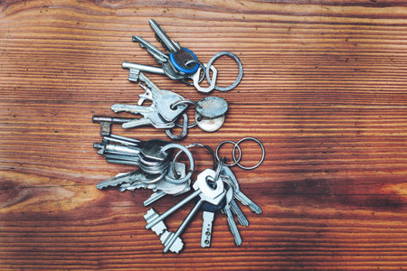 Bunch of keys on a wooden background. Selective focus.