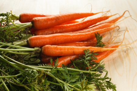 Carrots with leaves on a wooden tableの写真素材