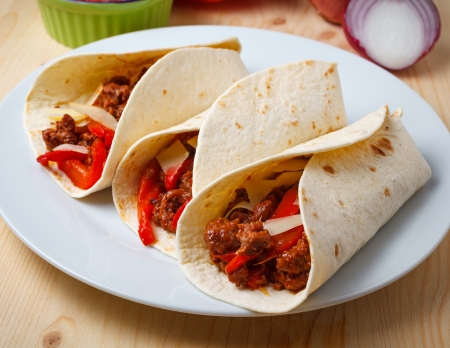 tortillas filled with  with beef meat, pepperoni, onions, cheese and tomato sauceの写真素材