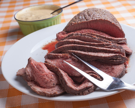 Roast beef on orange tartan tableclothの写真素材