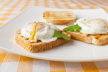 Poached eggs on white plateの写真素材