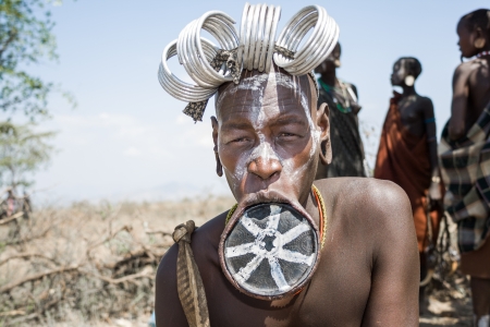 Woman of the Mursi ethnic group shows her typical lip plate, Debub Omo, Ethiopia  The Mursi are an...