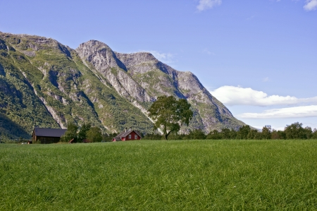 Green meadow and mountain in Norwegian landscapeの写真素材